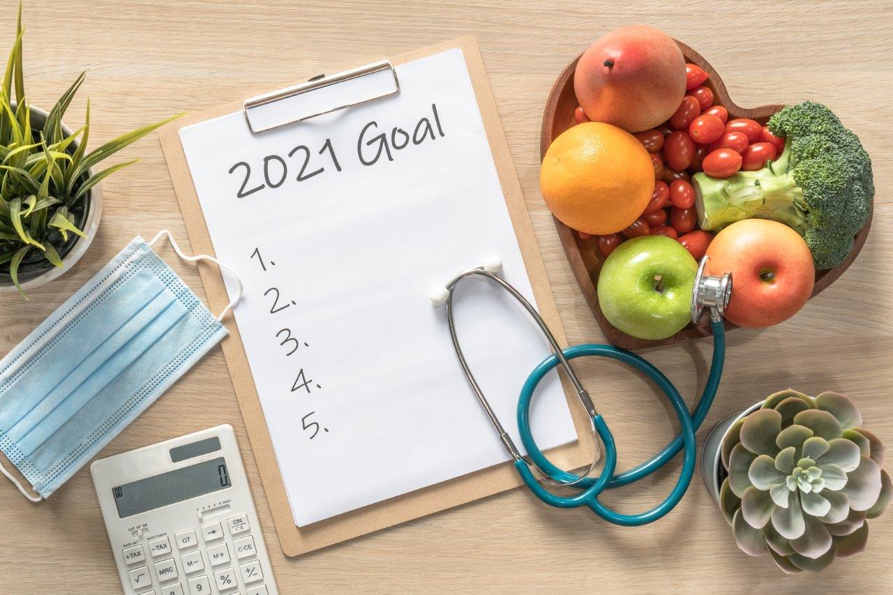 Healthy food and a notepad with "2021 Goal" written across the top