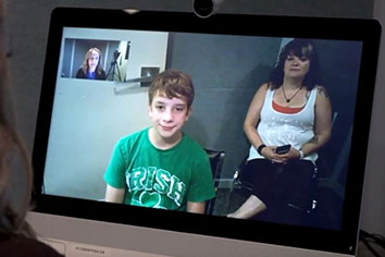 Computer screen showing video call between a woman and child, and another woman