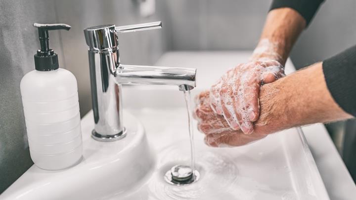 A person washes their hands with soap and water