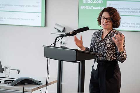 Dr. Réka Gustafson speaking at a microphone
