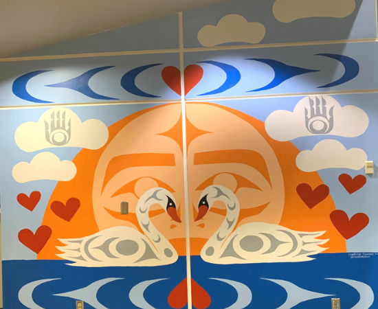 Mural showing two swans on rippled water in front of an orange sun on the horizon