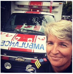 Marilyn Oberg in paramedic uniform with ambulance in the background