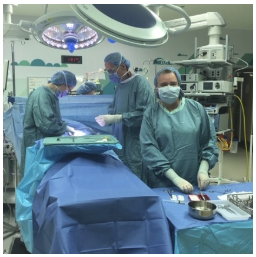 Three people in surgical scrubs in an operating room