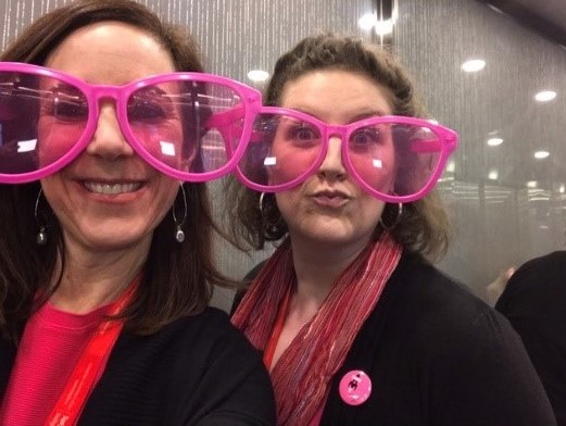 Carly and Sara wearing over-sized pink sunglasses