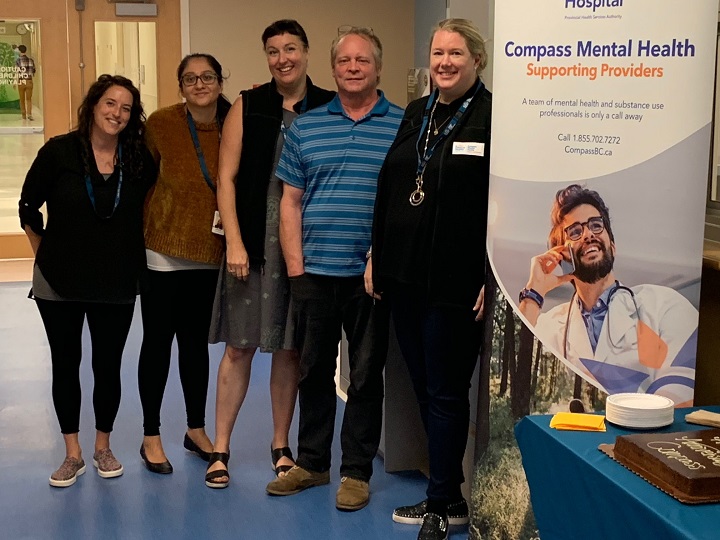 Five people next to a Compass Mental Health sign