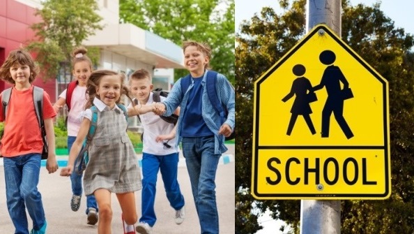 Children walking with backpacks and school zone sign