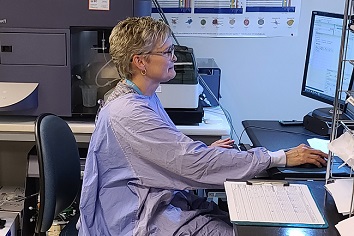 Lab technician at a computer desk