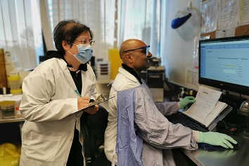 Two lab workers looking at a screen