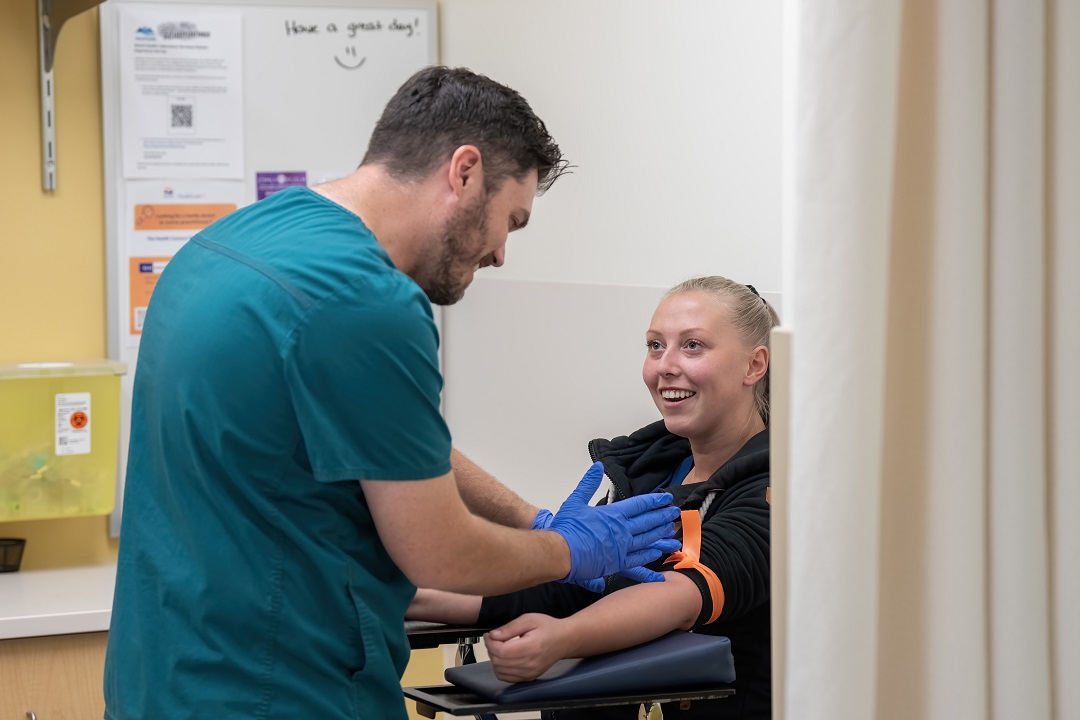 Lab technician drawing blood from a patient